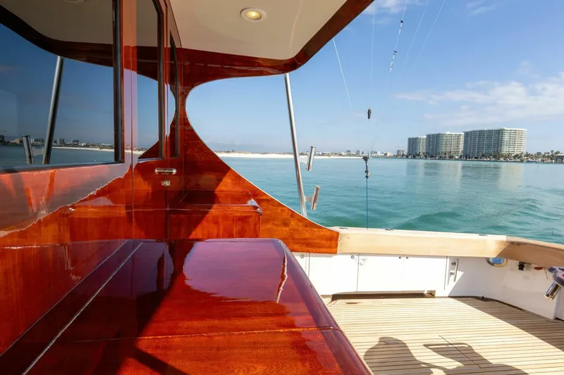 Patron Yacht Photos Pics Luxurious 2004 Custom Ebony Sportfish 65' yacht with polished wood deck, ocean view.