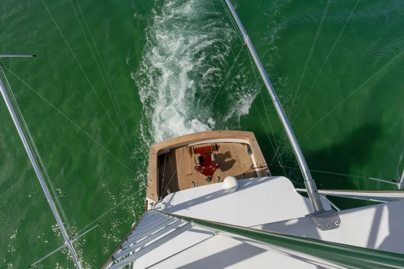 Patron Yacht Photos Pics Aerial view of 2004 Custom Ebony Sportfish 65' CNV yacht cruising on green water.