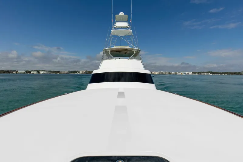 Patron Yacht Photos Pics Custom Ebony Sportfish 65' CNV yacht, 2004 model, cruising on calm waters under a clear sky.