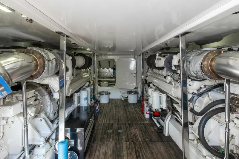 Patron Yacht Photos Pics Engine room of 2004 Custom Ebony Sportfish 65' CNV with dual engines and wooden flooring.