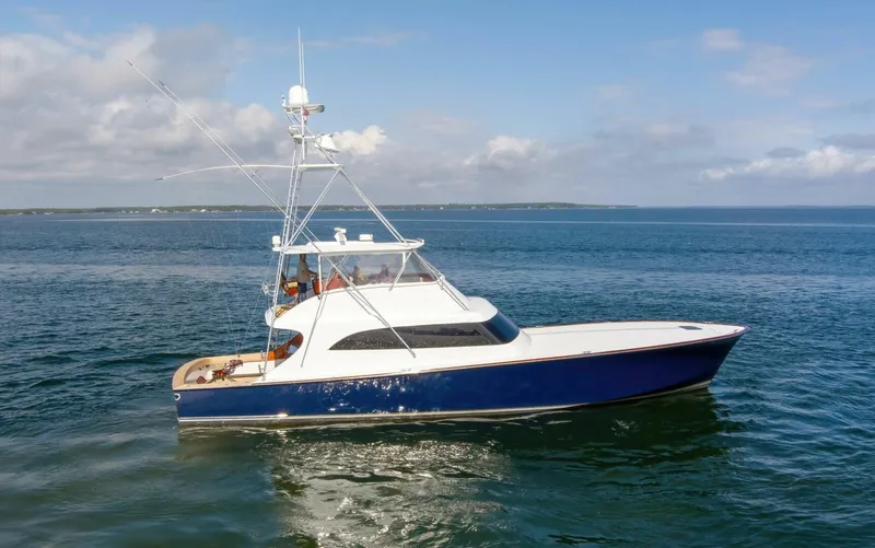 Patron Yacht Photos Pics Custom Ebony Sportfish 65 Convertible yacht, 2004 model, cruising on open water under a clear sky.