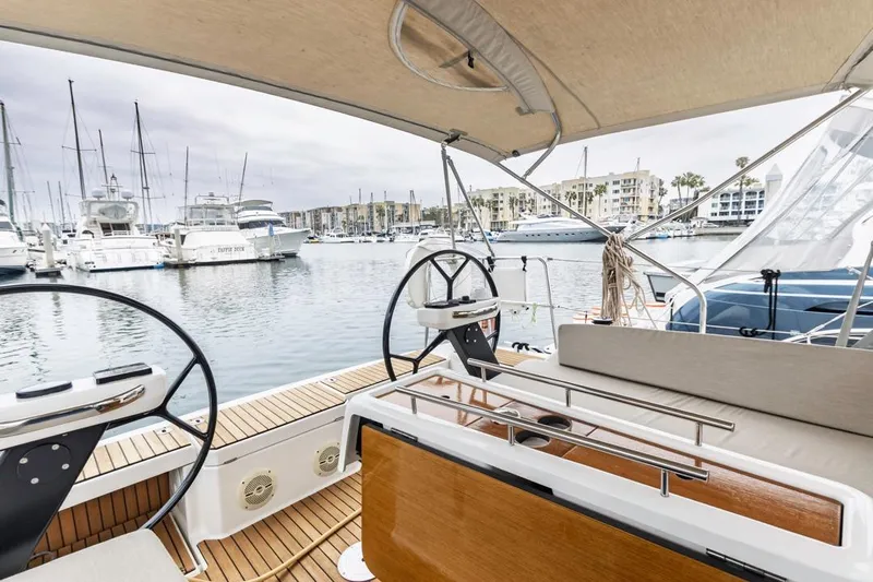 Dotwick Jinga Yacht Photos Pics 2020 Dufour 360 yacht cockpit with dual steering wheels in a marina setting.