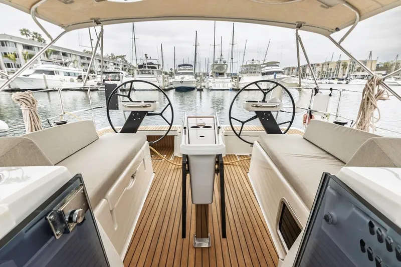 Dotwick Jinga Yacht Photos Pics 2020 Dufour 360 yacht cockpit with dual steering wheels, docked in a marina.