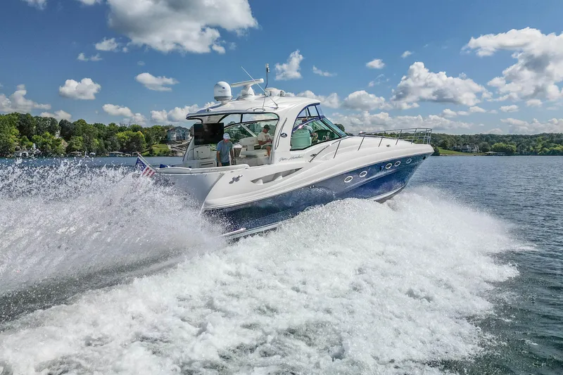 Night Moves Yacht Photos Pics 2005 Sea Ray 500 Sundancer yacht cruising on a sunny day with splashing waves.