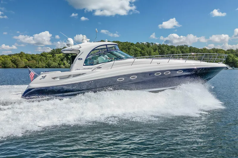 Night Moves Yacht Photos Pics 2005 Sea Ray 500 Sundancer yacht cruising on a sunny day with lush greenery in the background.