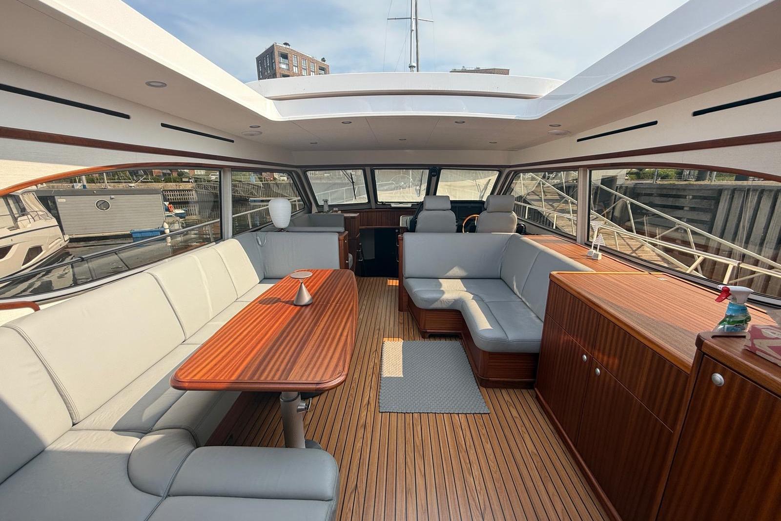 Luxurious interior of 2023 Elling E6 yacht with elegant wood and leather seating.
