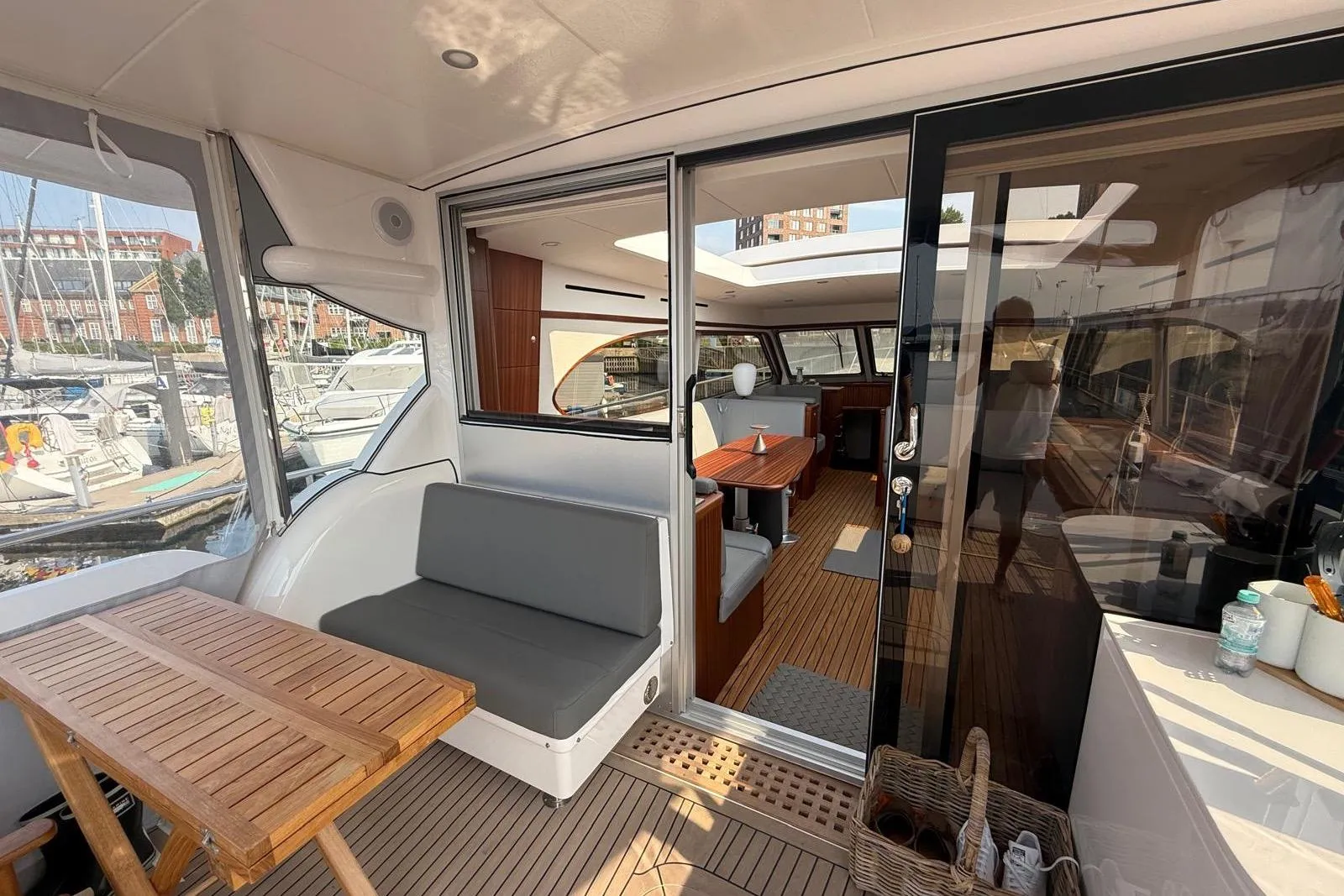 Luxurious 2023 Elling E6 yacht interior with seating and dining area, docked at a marina.