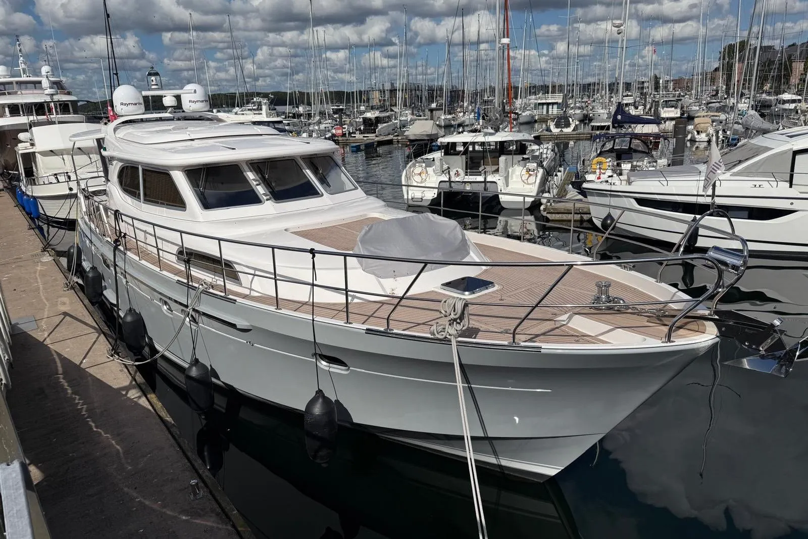2023 Elling E6 yacht docked in a marina under a cloudy sky.
