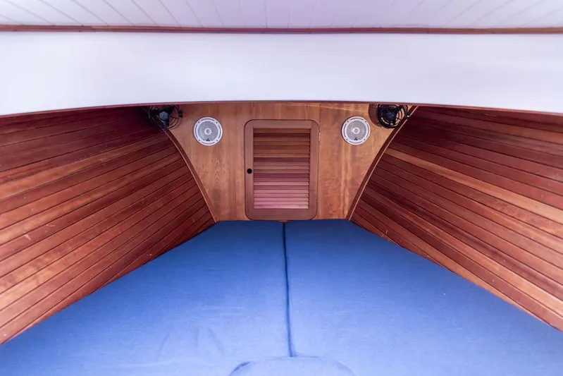 Belle Yacht Photos Pics Interior of 1998 Hinckley Picnic Boat with wooden paneling and blue cushions.