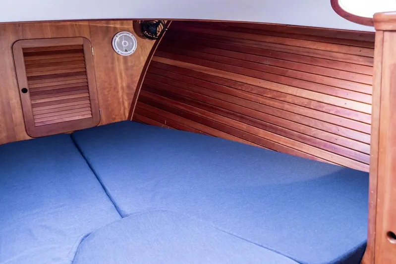 Belle Yacht Photos Pics 1998 Hinckley Picnic Boat interior with wooden paneling and blue cushioned seating.