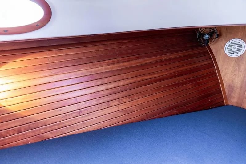 Belle Yacht Photos Pics Interior of a 1998 Hinckley Picnic Boat with wooden paneling and blue upholstery.