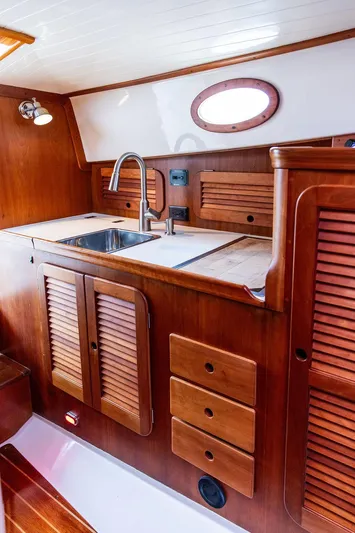 Belle Yacht Photos Pics 1998 Hinckley Picnic Boat interior with wooden cabinetry and stainless steel sink.