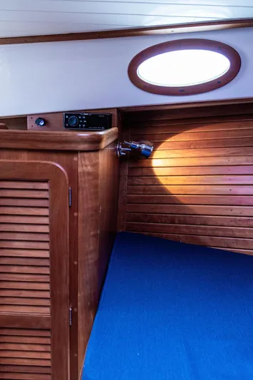Belle Yacht Photos Pics Interior of 1998 Hinckley Picnic Boat with wooden cabinetry and blue upholstery.