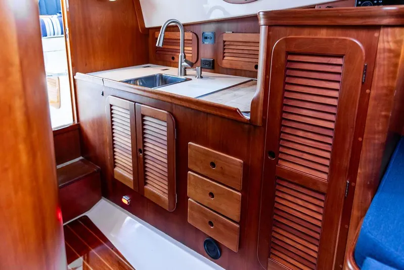 Belle Yacht Photos Pics Interior of 1998 Hinckley Picnic Boat with wooden cabinetry and stainless steel sink.