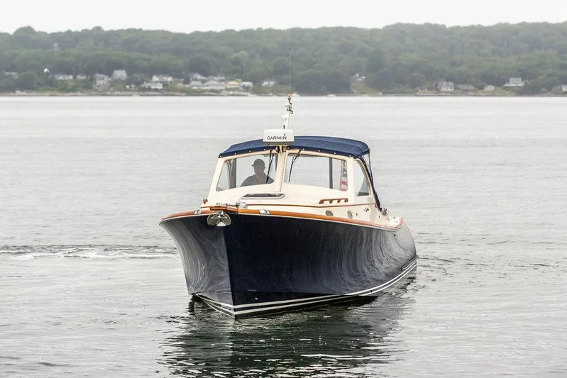 Belle Yacht Photos Pics 1998 Hinckley Picnic Boat cruising on calm waters with forested shoreline in background.