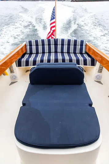 Belle Yacht Photos Pics 1998 Hinckley Picnic Boat with striped seating and American flag, cruising on water.