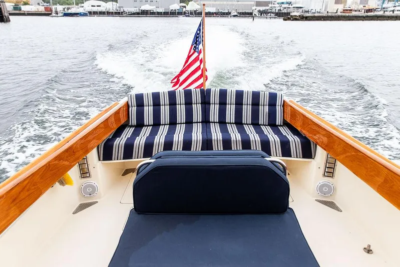 Belle Yacht Photos Pics 1998 Hinckley Picnic Boat with striped seating and American flag on open water.