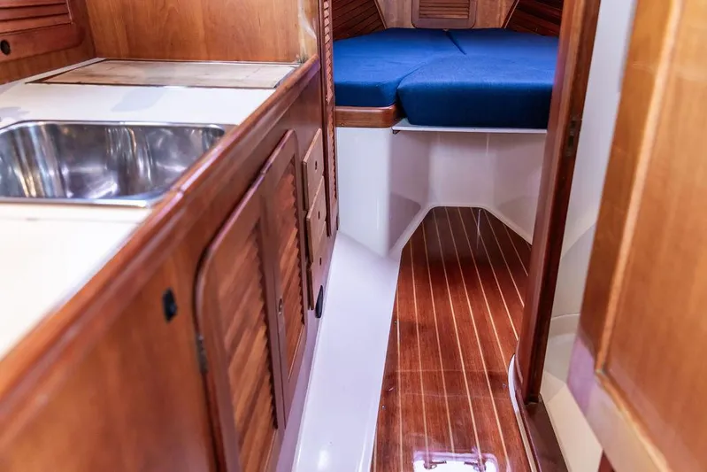 Belle Yacht Photos Pics Interior of a 1998 Hinckley Picnic Boat with wooden cabinetry and a cozy sleeping area.