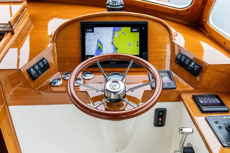 Belle Yacht Photos Pics Steering wheel and navigation system of a 1998 Hinckley Picnic Boat.