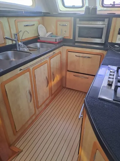  Yacht Photos Pics Galley kitchen in 2012 Royal Cape Catamarans Majestic 53 with wood cabinets and modern appliances.