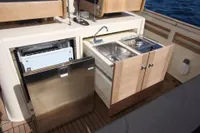 Compact kitchen area on 2010 Rhea 35 Open boat with sink, stove, and fridge.