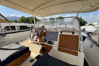 2010 Rhea 35 Open boat cockpit with steering wheel, dashboard, and navigation equipment.