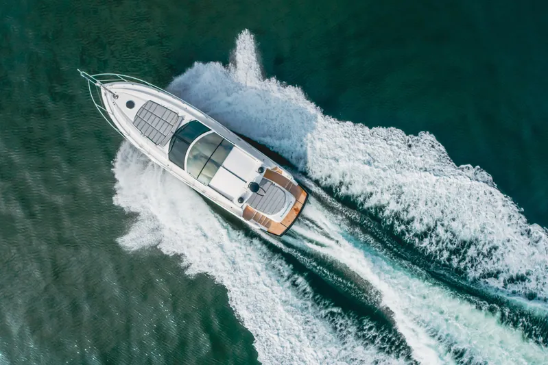 Tranquility Yacht Photos Pics Aerial view of 2012 Sunseeker Portofino 48 yacht cruising on open water.