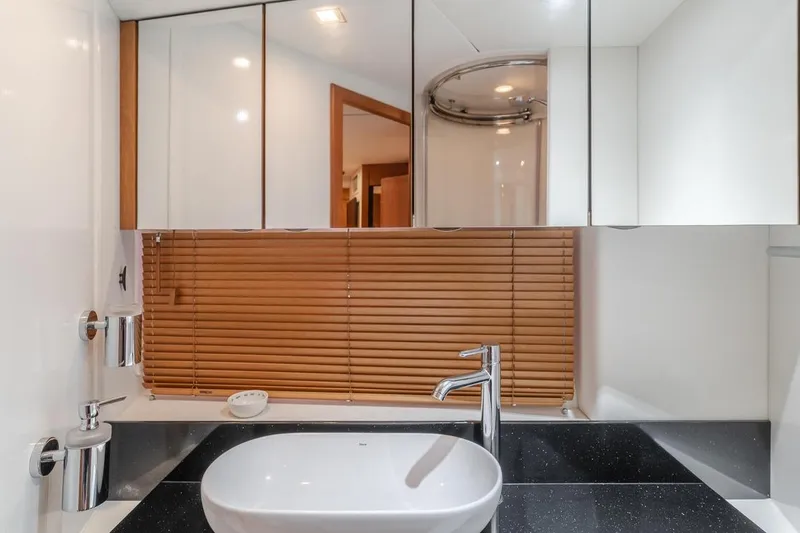 Tranquility Yacht Photos Pics Luxurious bathroom in 2012 Sunseeker Portofino 48 yacht with modern sink and wooden blinds.