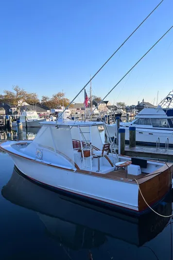 Charmer Yacht Photos Pics 1985 Rybovich 32 Express Walkaround Sportfish docked in a marina under clear blue sky.