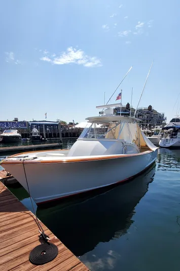 Charmer Yacht Photos Pics 1985 Rybovich 32 Express Walkaround Sportfish docked at marina under clear sky.