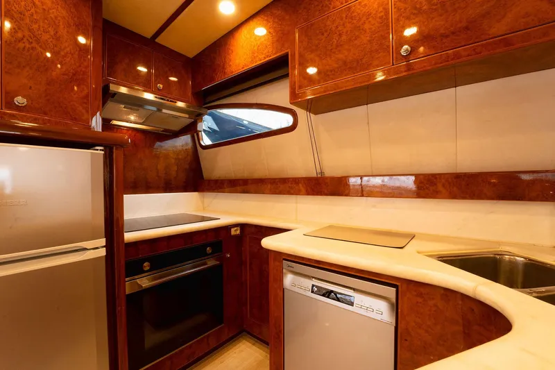 Ma Bella Yacht Photos Pics Luxurious kitchen interior of 1999 Monte Fino 72 yacht with modern appliances and wood finish.