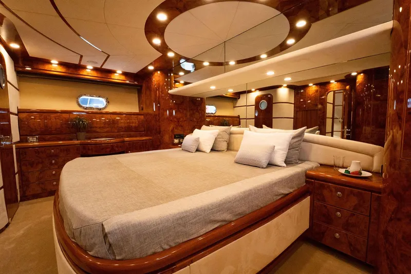 Ma Bella Yacht Photos Pics Luxurious interior of 1999 Monte Fino 72 yacht with elegant wood finishes and plush bedding.