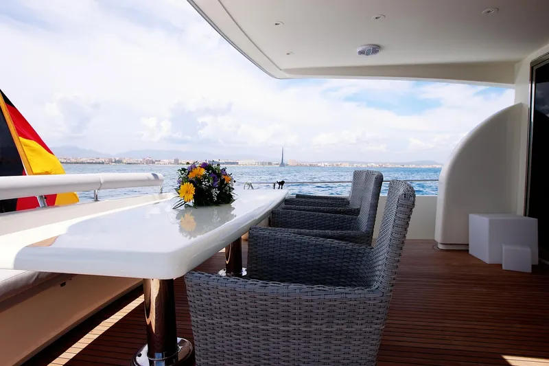 Ma Bella Yacht Photos Pics Luxurious Monte Fino 72 yacht deck with dining area, ocean view, and floral centerpiece, 1999 model.