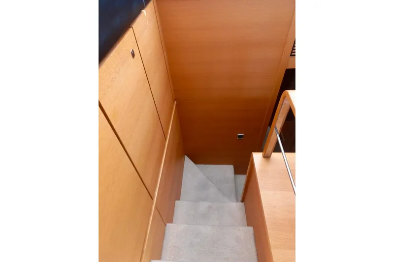 Zero One Yacht Photos Pics Staircase inside 2012 Fairline Squadron 65 yacht with wooden paneling and carpeted steps.