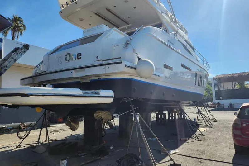 Zero One Yacht Photos Pics 2012 Fairline Squadron 65 yacht on dry dock for maintenance under clear blue sky.
