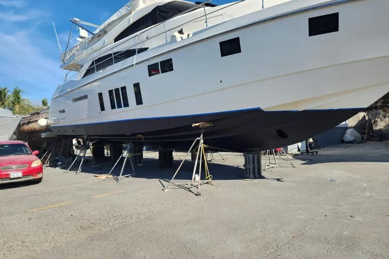 Zero One Yacht Photos Pics 2012 Fairline Squadron 65 yacht on dry dock for maintenance under clear blue sky.