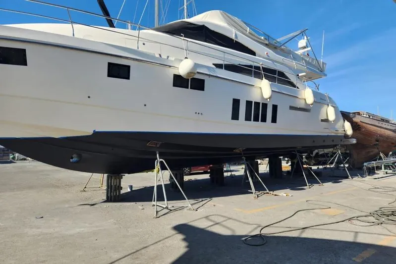 Zero One Yacht Photos Pics 2012 Fairline Squadron 65 yacht on dry dock for maintenance under clear blue sky.