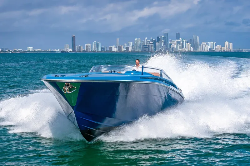 Jam Yacht Photos Pics Magnum 51 Bestia yacht cruising near city skyline, 2013 model, creating waves.