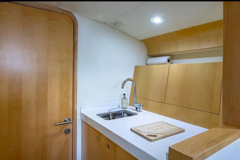 Jam Yacht Photos Pics Compact kitchen area in 2013 Magnum 51 Bestia yacht with wooden cabinetry and modern sink.