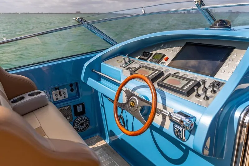 Jam Yacht Photos Pics Cockpit of 2013 Magnum 51 Bestia yacht with blue dashboard and wooden steering wheel.