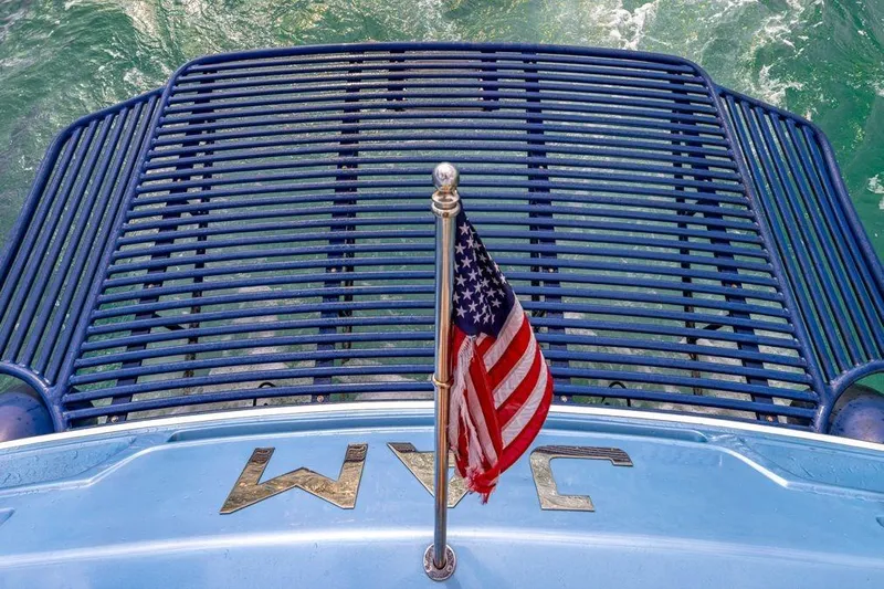 Jam Yacht Photos Pics Rear view of 2013 Magnum 51 Bestia yacht with American flag and water backdrop.