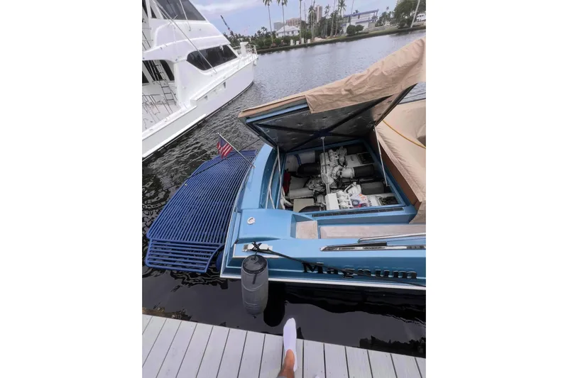 Jam Yacht Photos Pics 2013 Magnum 51 Bestia boat docked, engine compartment open, with American flag.