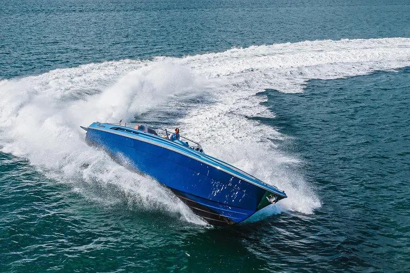 Jam Yacht Photos Pics Blue 2013 MAGNUM MARINE 51 Bestia powerboat speeding on ocean, creating dynamic waves.
