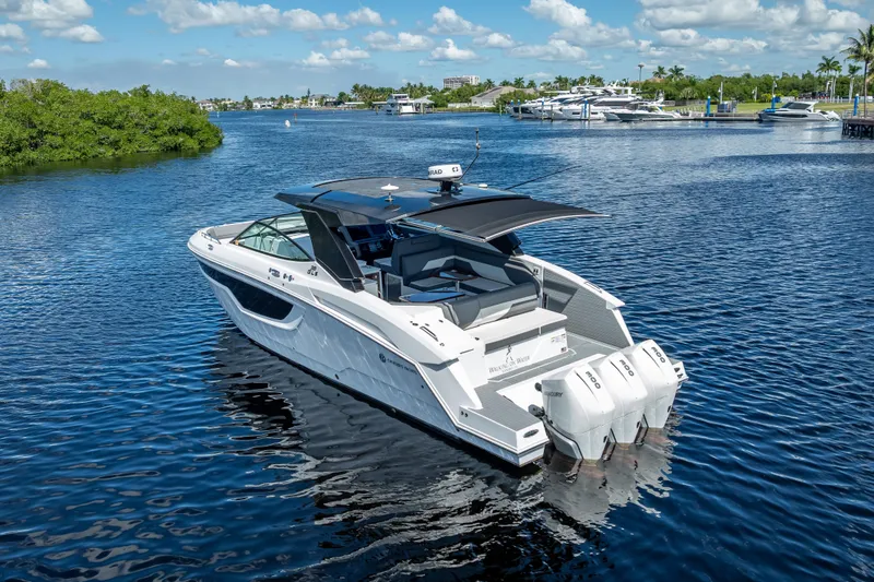  Yacht Photos Pics 2022 Cruisers Yachts 38 GLS OB on serene water, showcasing sleek design and triple outboard engines.