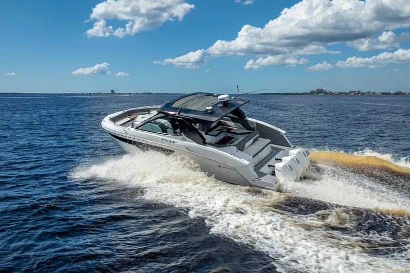  Yacht Photos Pics 2022 Cruisers Yachts 38 GLS OB speeding on open water under a blue sky.