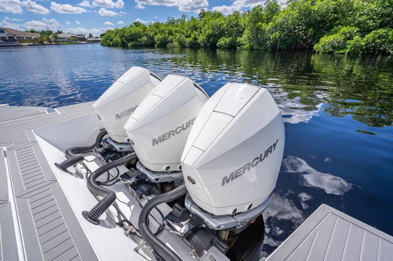  Yacht Photos Pics 2022 Cruisers Yachts 38 GLS OB with triple Mercury outboard engines on a serene waterway.