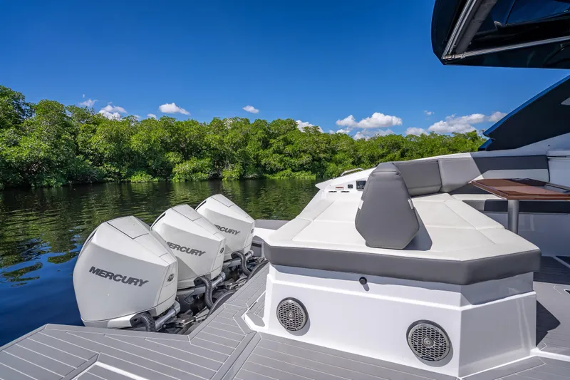  Yacht Photos Pics 2022 Cruisers Yachts 38 GLS OB with Mercury engines, docked by lush greenery.