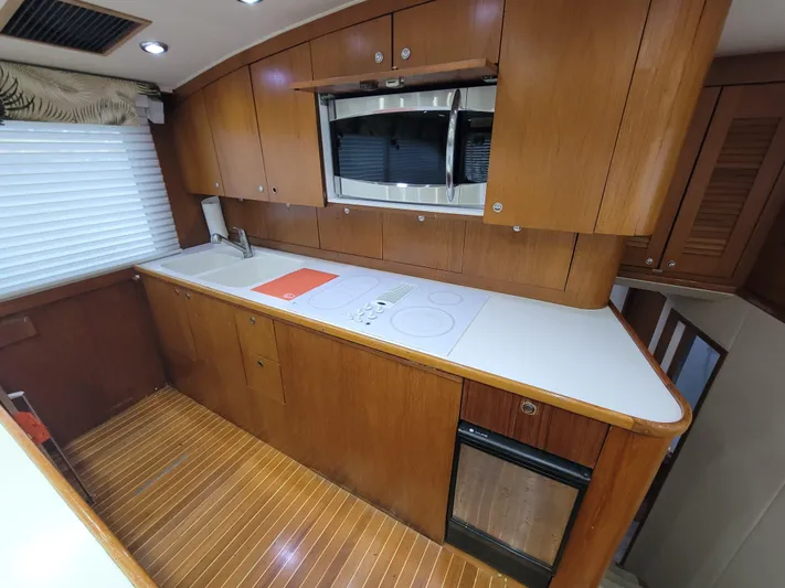  Yacht Photos Pics Interior of 1998 Buddy Davis 65 Carolina Custom yacht kitchen with wood cabinetry and modern appliances.