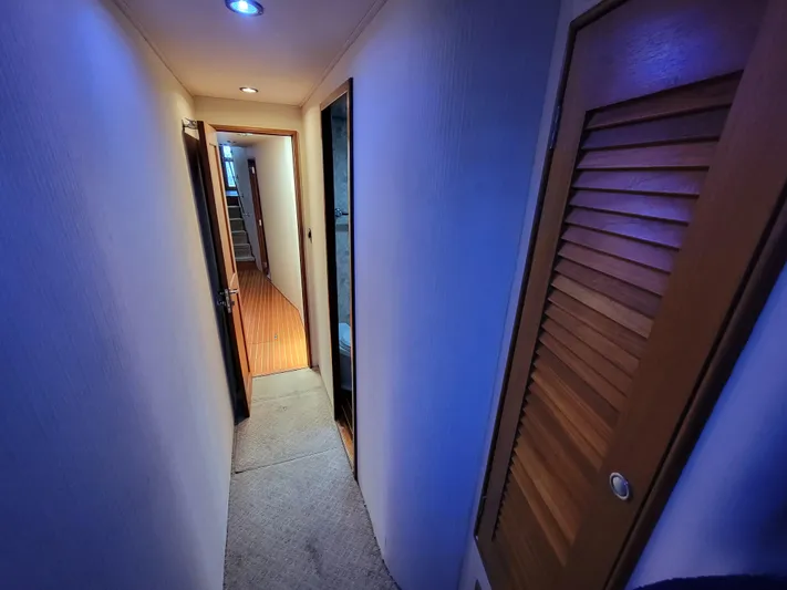  Yacht Photos Pics Narrow hallway inside 1998 Buddy Davis 65 Carolina Custom yacht with wooden doors and carpeted floor.