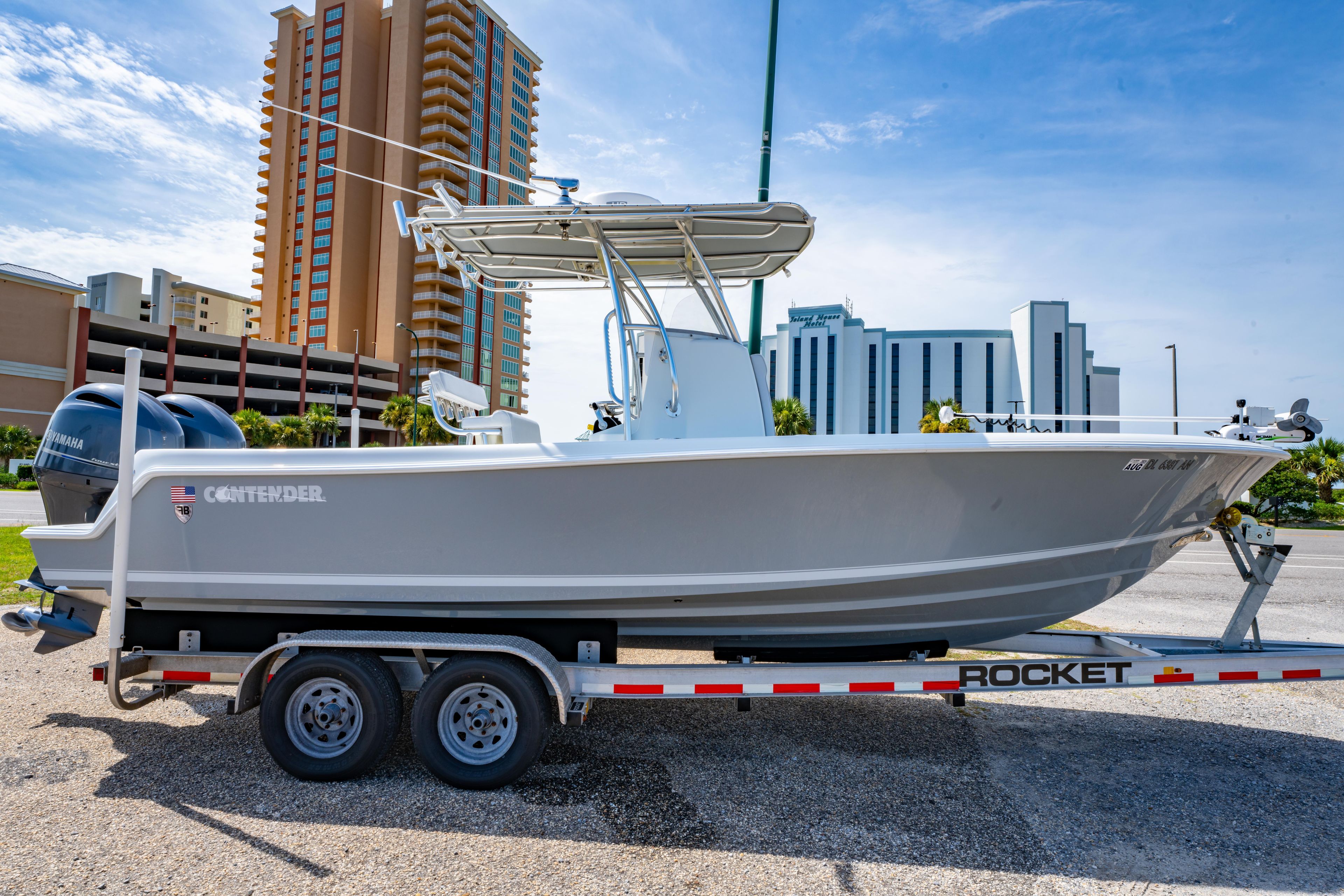 2022 Contender 25T boat on trailer, parked near tall buildings under a clear sky.